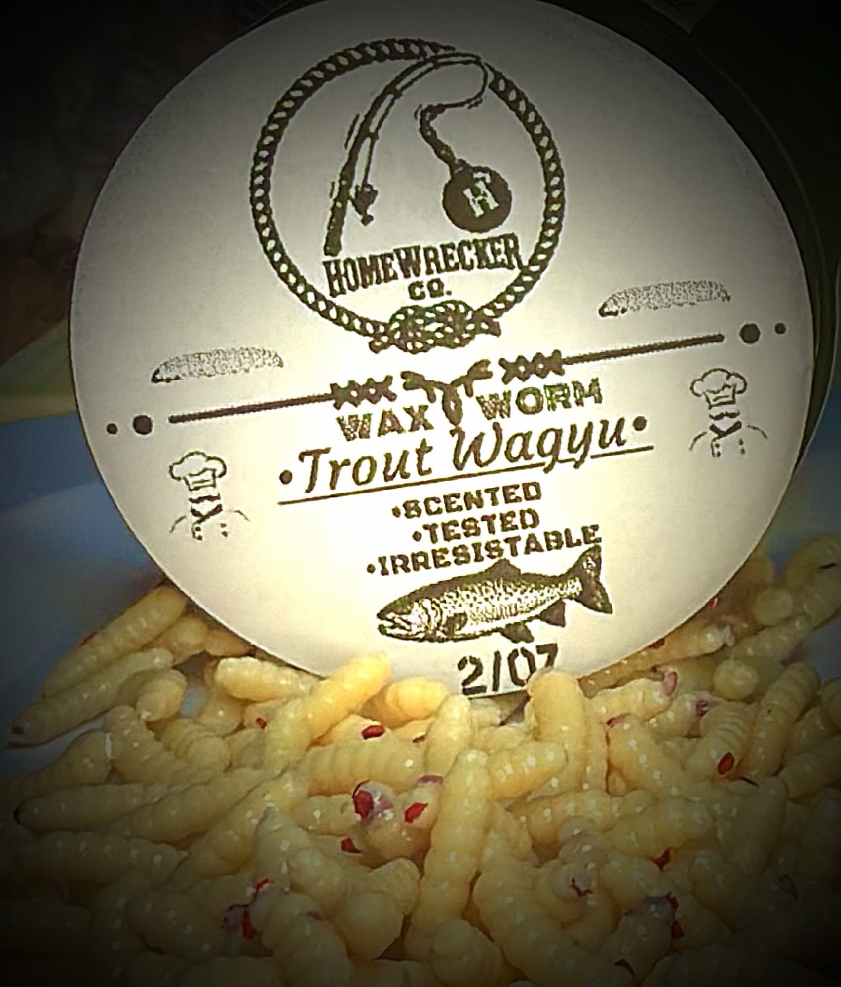 Homewrecker Wax Worm trout bait jar staged on moss and river rock